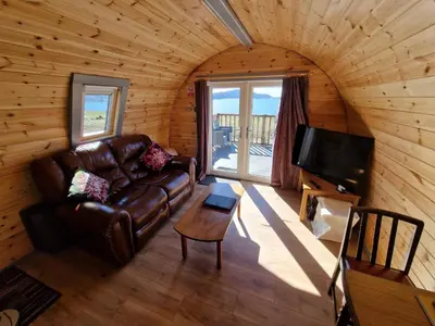 a living room with a couch and a tv at Dalrigh Pod in Onich