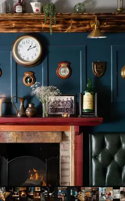 a fireplace with a clock on a blue wall at The Rhu Inn in Rhu