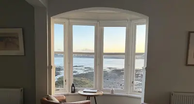 a large window with a view of the ocean at The Rhu Inn in Rhu