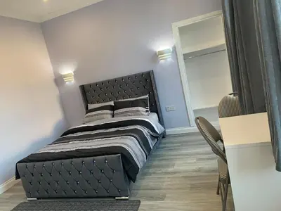 a bedroom with a bed with a black headboard at Ibrox Argyll Inn in Glasgow