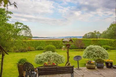 a garden with a bench and a bird house at The Corran in Lochgilphead