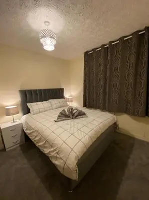 a bedroom with a bed with a bow on it at 3 bedroom home-inverkeithing in Fife