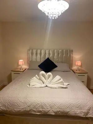 a bedroom with a bed with two white towels on it at 3 bedroom home-inverkeithing in Fife