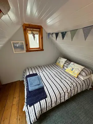 a bedroom with a bed in a tiny house at 3 bedroom cosy cottage in Lamlash, Isle Of Arran in Lamlash