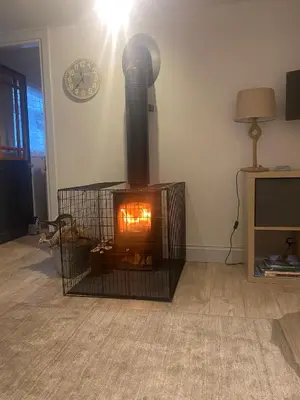a fireplace in a room with a clock on the wall at 3 bedroom cosy cottage in Lamlash, Isle Of Arran in Lamlash