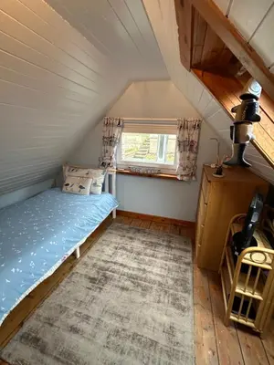 a small bedroom with a bed in a attic at 3 bedroom cosy cottage in Lamlash, Isle Of Arran in Lamlash