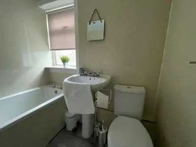 a bathroom with a toilet and a sink and a tub at Cardonald House in Glasgow