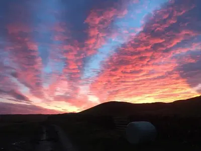 a sunset with a colorful sky with clouds at Croft Cottage in Gatehouse of Fleet