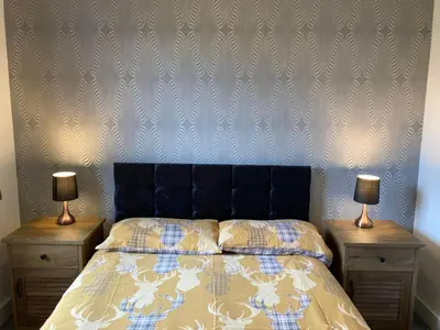 a bedroom with a bed with two lamps on night stands at Svarga Mountain View in Kinlochleven