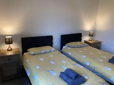 a bedroom with two beds and two night stands at Svarga Mountain View in Kinlochleven