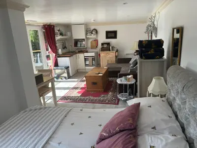 a living room with a couch and a kitchen at Unique Orchard Lodge for couples with hot tub in Strathaven