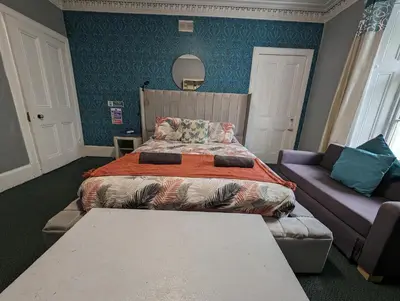 a bedroom with a bed and a couch at Bonnyside House in Bonnybridge