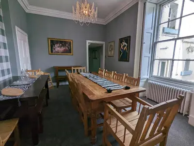 a dining room with a wooden table and chairs at Bonnyside House in Bonnybridge