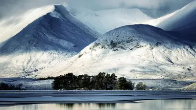 a snow covered mountain with a lake in front of it at Creran Apartment, Kinlochlaich House in Appin