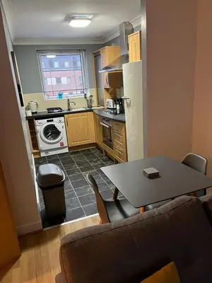 a small kitchen with a table and a dining room at Ferry Gait Apartments in Edinburgh