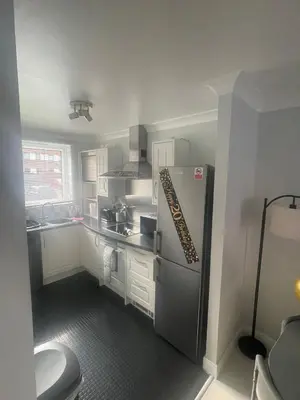 a kitchen with a stainless steel refrigerator and a sink at Ferry Gait Apartments in Edinburgh