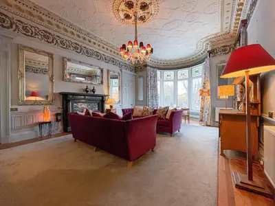 a living room with a couch and a chandelier at 1 Bed Character Filled Glasgow Apartment in Glasgow
