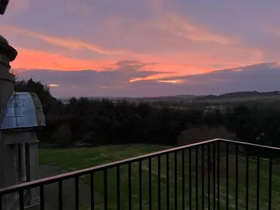 a view of a sunset from the balcony of a house at The Keep at Craigiehall in Edinburgh