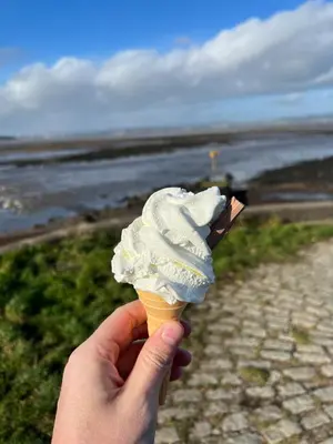 a person holding an ice cream cone at the beach at The Keep at Craigiehall in Edinburgh