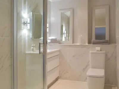 a white bathroom with a shower and a toilet at Whitehouse Studio in Roslin