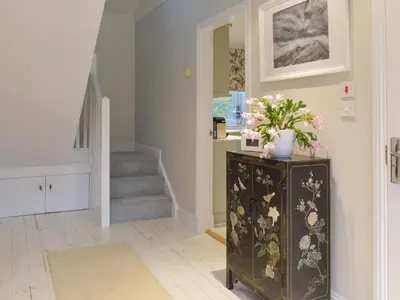a hallway with a dresser with flowers on it at Whitehouse Studio in Roslin