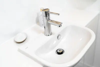 a white bathroom sink with a silver faucet at Cultybraggan Hut 35 in Comrie