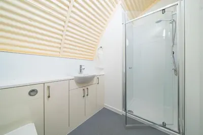 a bathroom with a sink and a shower at Cultybraggan Hut 35 in Comrie