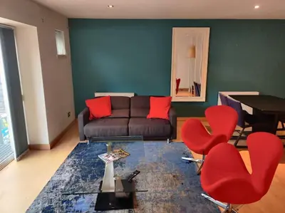 a living room with a couch and red chairs at West End & EICC with Parking in Edinburgh
