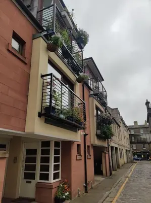 a building with potted plants and balconies on a street at West End & EICC with Parking in Edinburgh