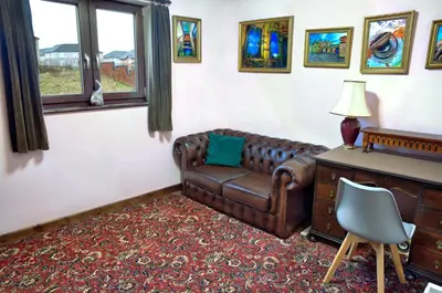 a living room with a leather couch and a desk at A cosy house near the city centre in Glasgow