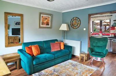 a living room with a blue couch and a chair at A cosy house near the city centre in Glasgow