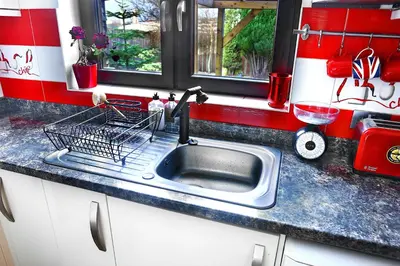 a kitchen sink with a dish drying rack next to it at A cosy house near the city centre in Glasgow