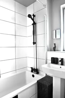 a white bathroom with a tub and a sink at A cosy house near the city centre in Glasgow
