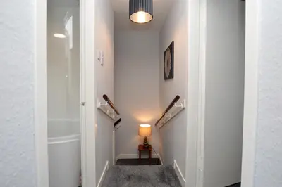a hallway with a staircase with a light and a lamp at Anchor View in Ardrishaig
