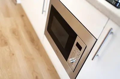 a microwave oven on a counter next to a door at Cultybraggan Hut 34 in Mill of Fortune