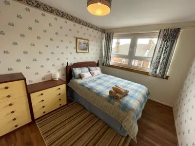 a bedroom with a bed with a teddy bear on it at West End Hidden Gem - Modern 2-Bedroom Apartment with residents patio in Anniesland