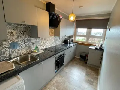 a kitchen with a sink and a counter top at West End Hidden Gem - Modern 2-Bedroom Apartment with residents patio in Anniesland