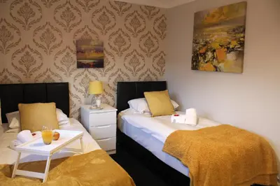 a bedroom with two beds and a table with a tray of juice at PREMIER - Fleming Apartment in Hamilton