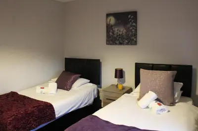 a bedroom with two beds and a picture on the wall at PREMIER - Fleming Apartment in Hamilton