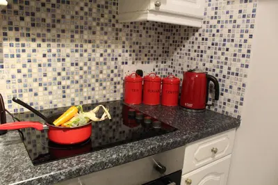 a kitchen counter with red containers on a counter top at PREMIER - Fleming Apartment in Hamilton