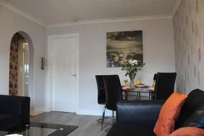 a living room with a table and chairs at PREMIER - Fleming Apartment in Hamilton