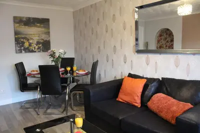 a living room with a black couch and a table at PREMIER - Fleming Apartment in Hamilton