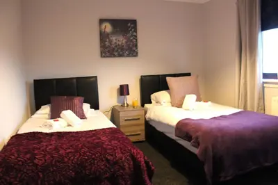 a bedroom with two beds and a night stand at PREMIER - Fleming Apartment in Hamilton