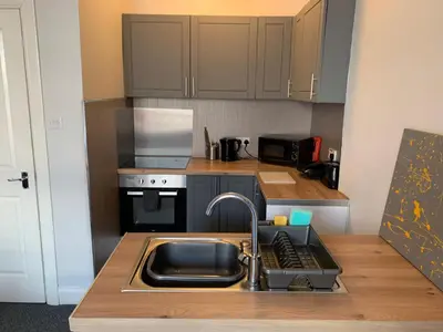 a small kitchen with a sink and a stove at Nelson st (MAYBOLE) in Largs