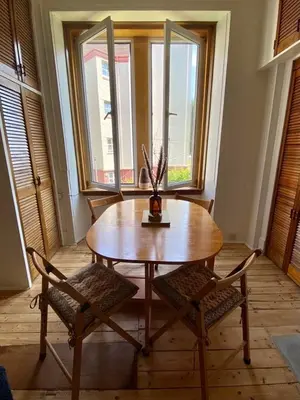a wooden table with two chairs and a vase on it at Lovely flat overlooking the Clyde in Gourock