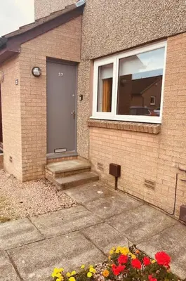 a house with a door and flowers in front of it at Glenbervie - Beautifully refurbished, self-contained apartment in Fife