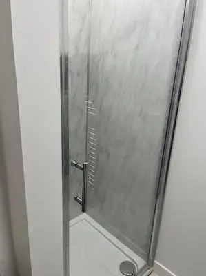 a shower with a glass door in a bathroom at Glenbervie - Beautifully refurbished, self-contained apartment in Fife