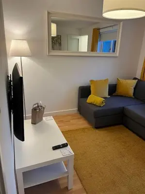 a living room with a blue couch and a tv at Glenbervie - Beautifully refurbished, self-contained apartment in Fife
