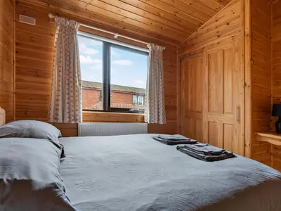 a bedroom with a bed and a large window at Chalet Loch Side Lodge 8 by Interhome in Kinross