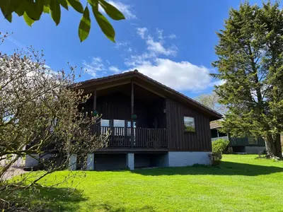 a house with a balcony on a lawn at Amazing Loch Views in Kilmun